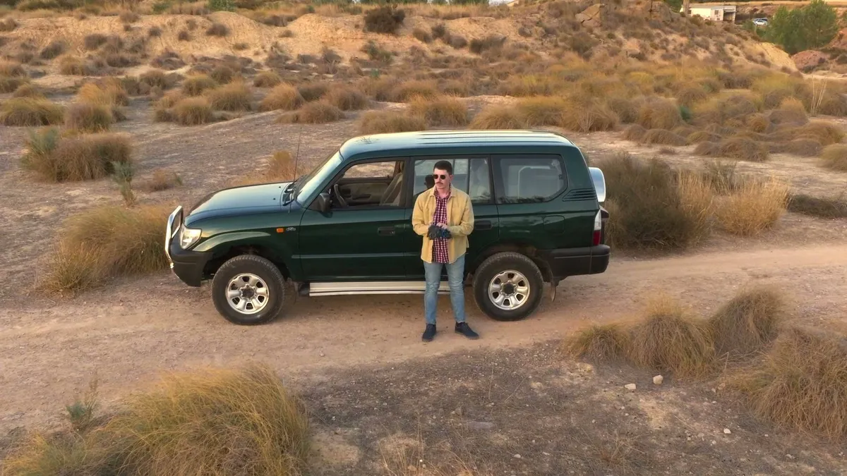 Plano aéreo de un todoterreno detenido en el monte durante un rodaje