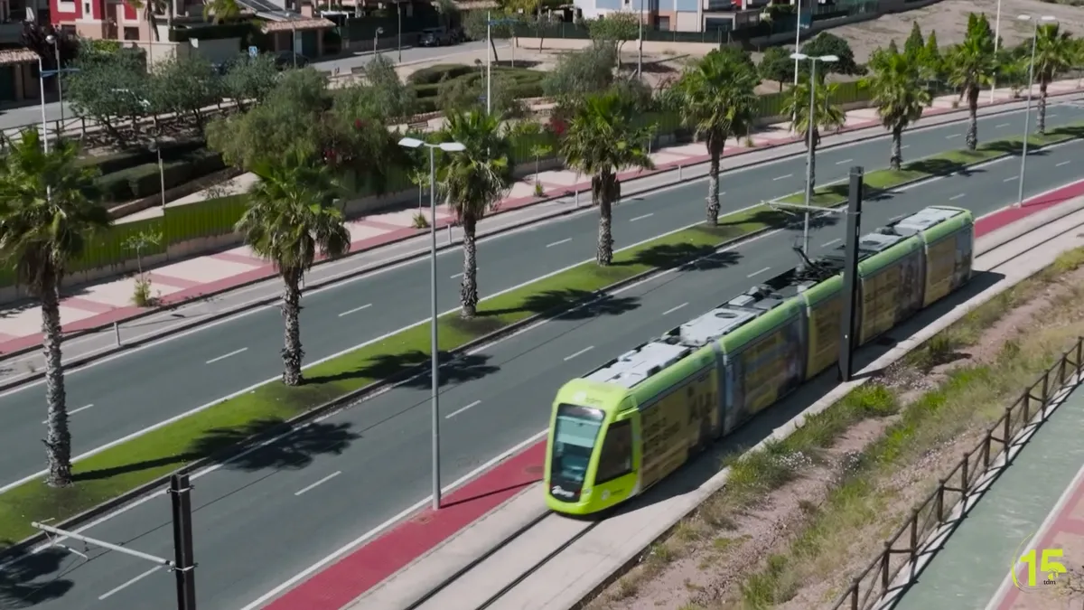 Plano aéreo de un tranvía de Murcia junto a una avenida